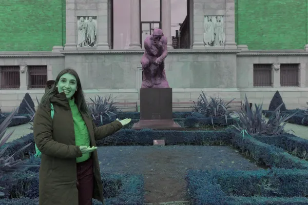 Guida indica la scultura del Pensatore nel giardino di un museo